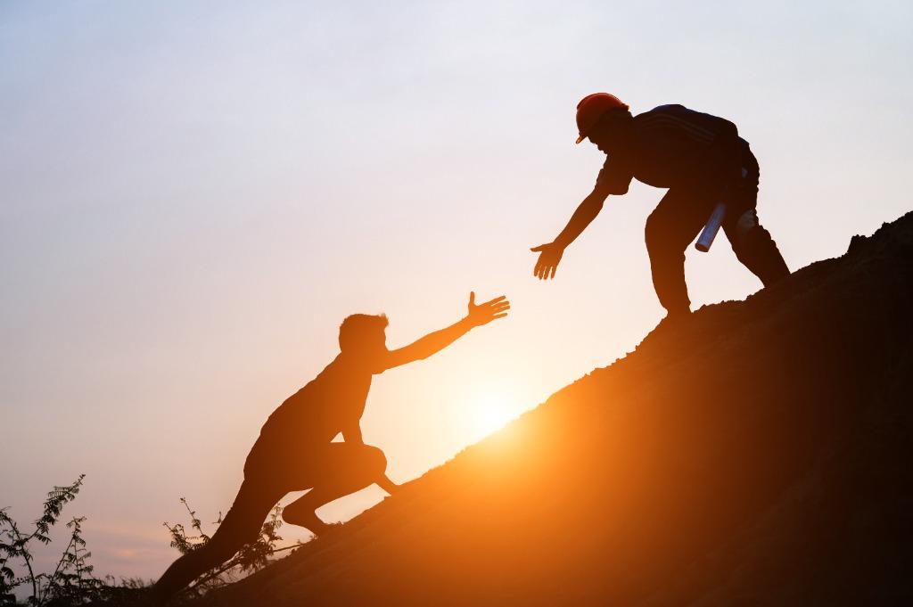 People helping each other climb, symbolizing community empowerment